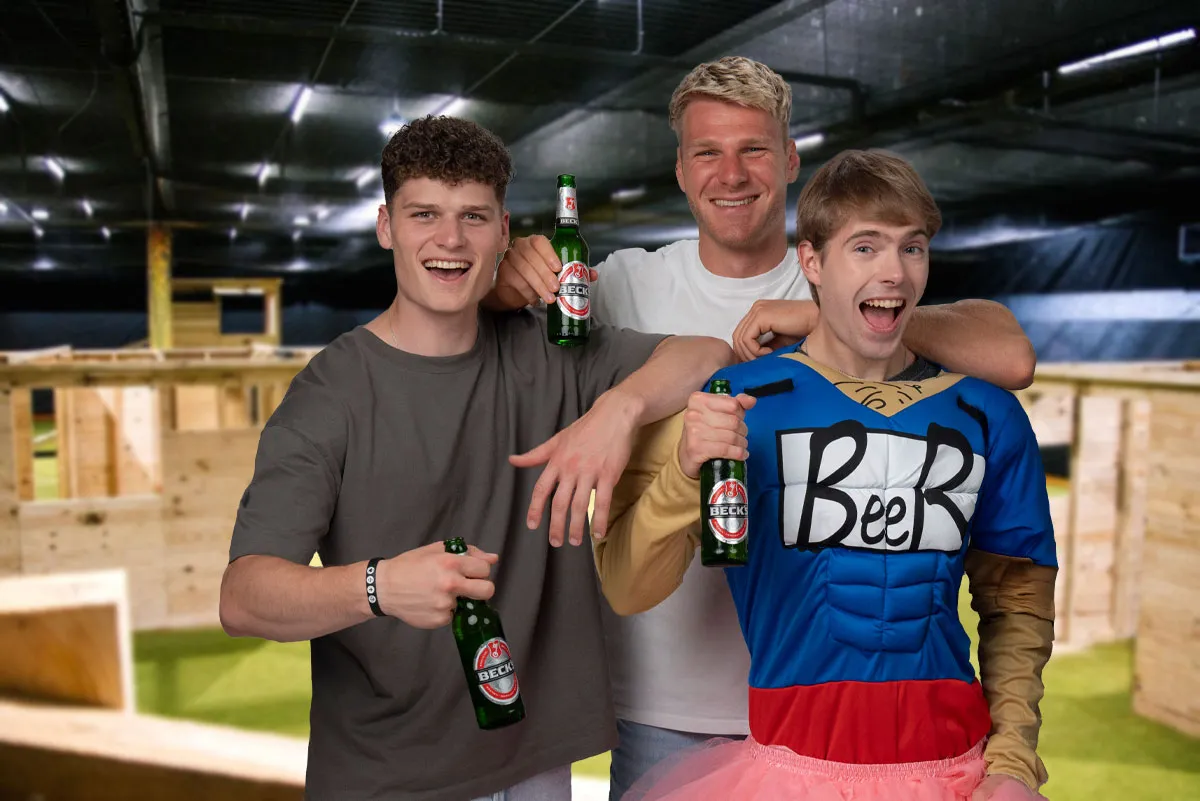 Drei maenner posieren mit bier beim Junggesellenabschied in der paintballzone